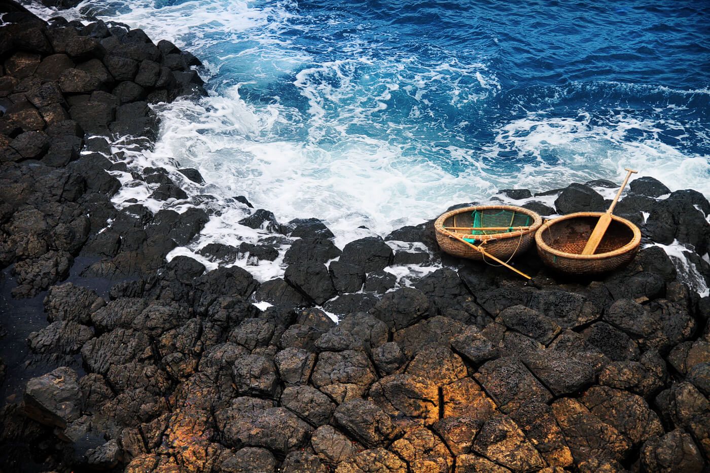 Đến nơi đây, các bạn sẽ bắt gặp những chiếc thuyền thúng nằm nghiêng mình trên những phiến đá như hình ảnh con thuyền mãi ở bến chờ biển đi xa sẽ về. (ảnh: internet) 