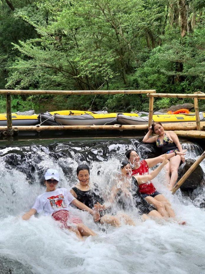 Các du khách đang đắm mình dưới dòng thác tại Công viên Ozo