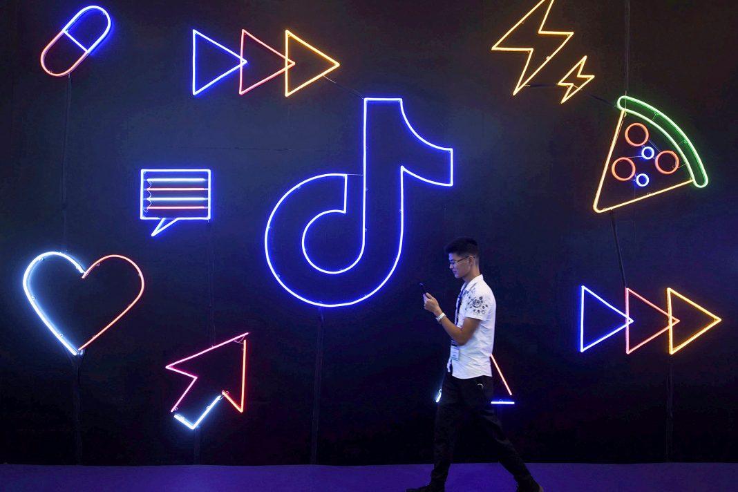 Image: FILE PHOTO: Man walks past a sign of ByteDance's app TikTok, known locally as Douyin, at an expo in Hangzhou