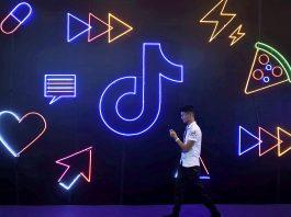 Image: FILE PHOTO: Man walks past a sign of ByteDance s app TikTok, known locally as Douyin, at an expo in Hangzhou