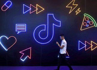 Image: FILE PHOTO: Man walks past a sign of ByteDance s app TikTok, known locally as Douyin, at an expo in Hangzhou