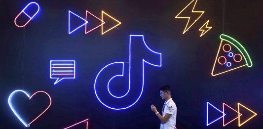 Image: FILE PHOTO: Man walks past a sign of ByteDance s app TikTok, known locally as Douyin, at an expo in Hangzhou