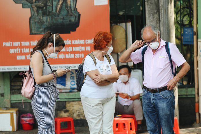 Các du khách nước ngoài đeo khẩu trang khi đi du lich tại Việt Nam mùa Corona 