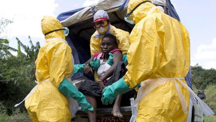 Cảnh nhân viên y tế đưa bệnh nhân đến trung tâm điều trị Ebola tại châu Phi vào năm 2014.