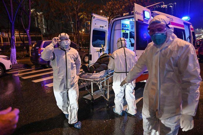 Cảnh nhân viên y tế ở Vũ Hán đưa bệnh nhân nhiễm bệnh lên xe cứu thương hồi tháng 1