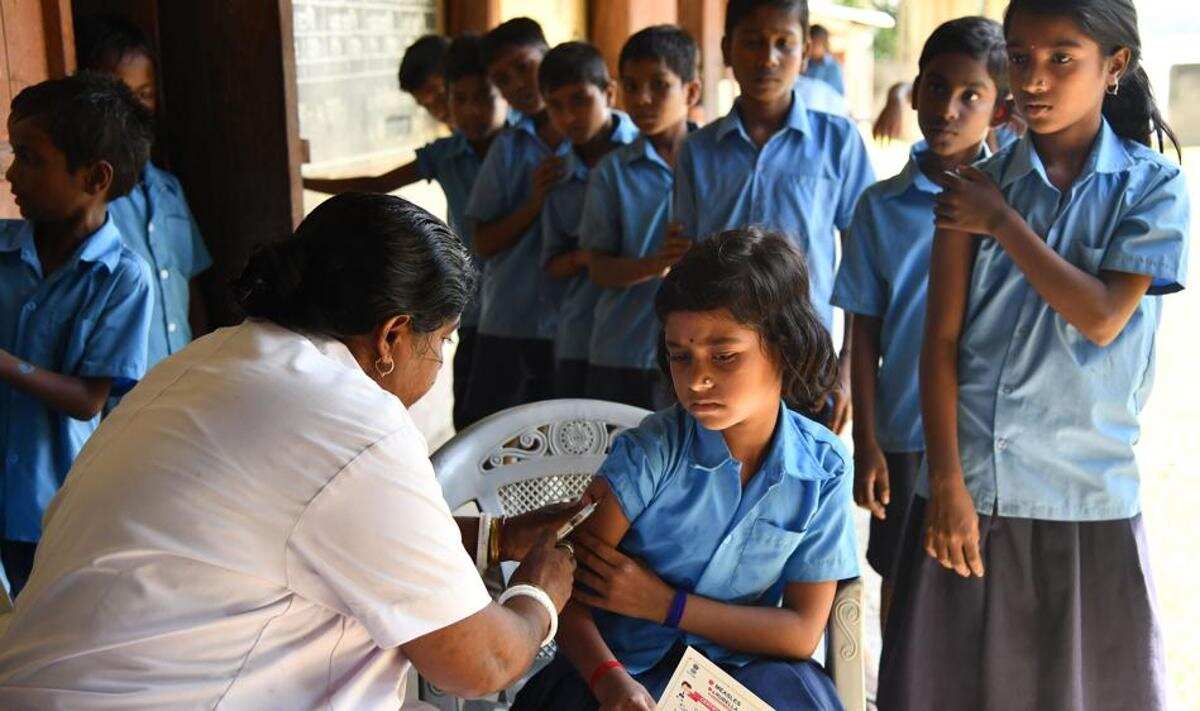 Nhân viên y tế Ấn Độ tiêm vắc xin sởi cho học sinh tại một trường học vào năm 2018.