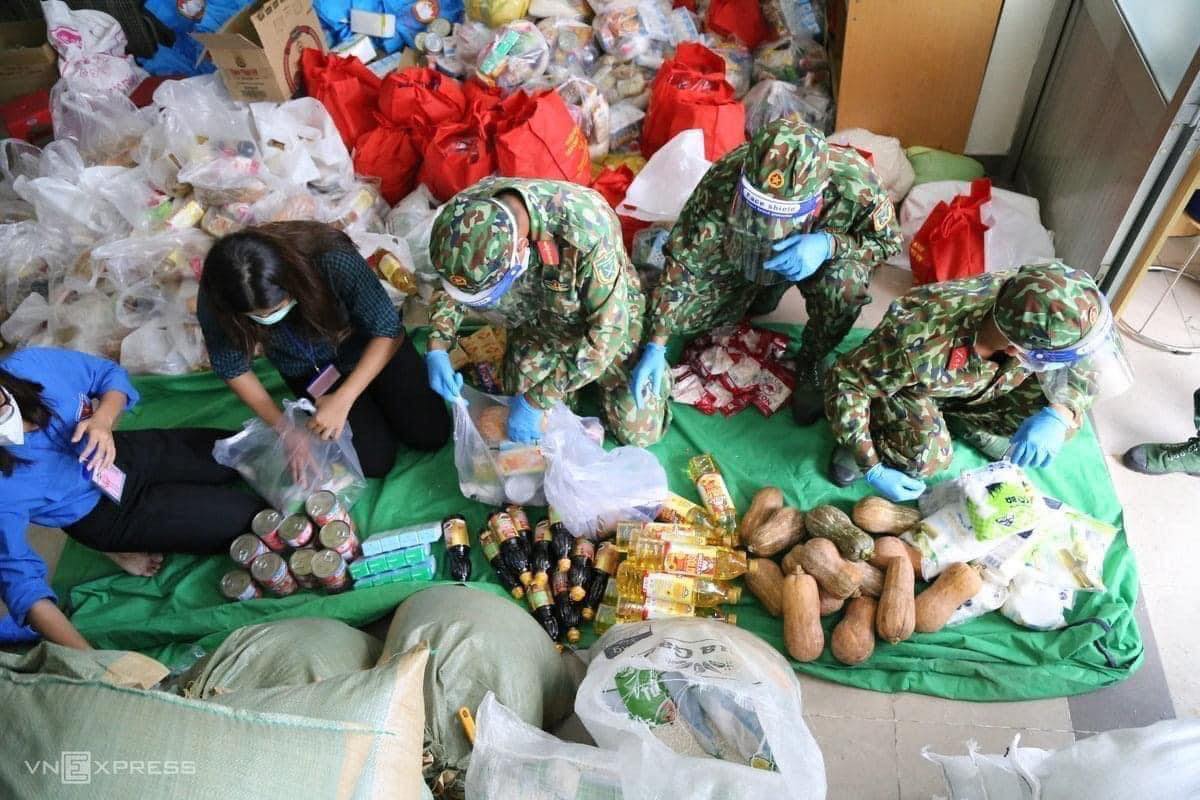 Các chiến sĩ bộ đội phân chia, đóng gói lương thực để vận chuyển cho người dân. (Ảnh: Internet)