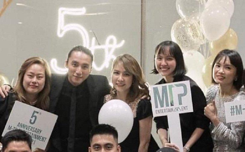 Hải Tú (đứng thứ 2 từ phải sang) xuất hiện trong ảnh kỷ niêm 5 năm thành lập công ty quản lý M-TP Entertaiment (Ảnh: Internet).