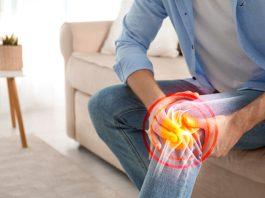Man suffering from knee pain at home, closeup