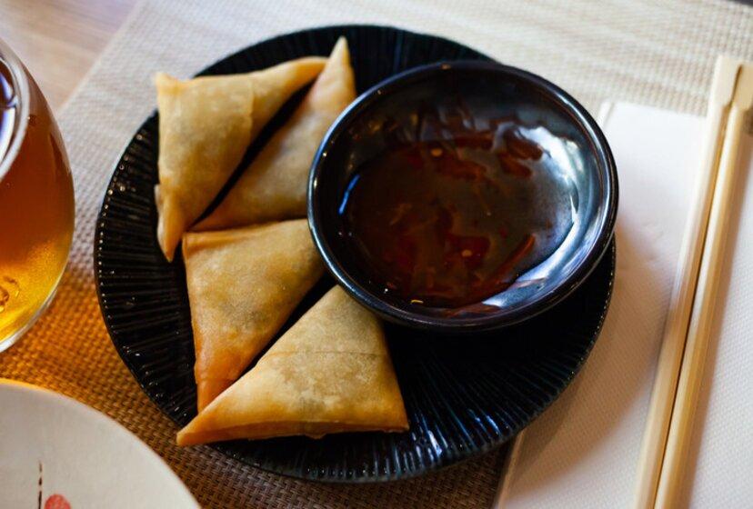 Traditional Portuguese dish with Asian twist - samosas or chamucas filled with spicy curry leaves served with sauce