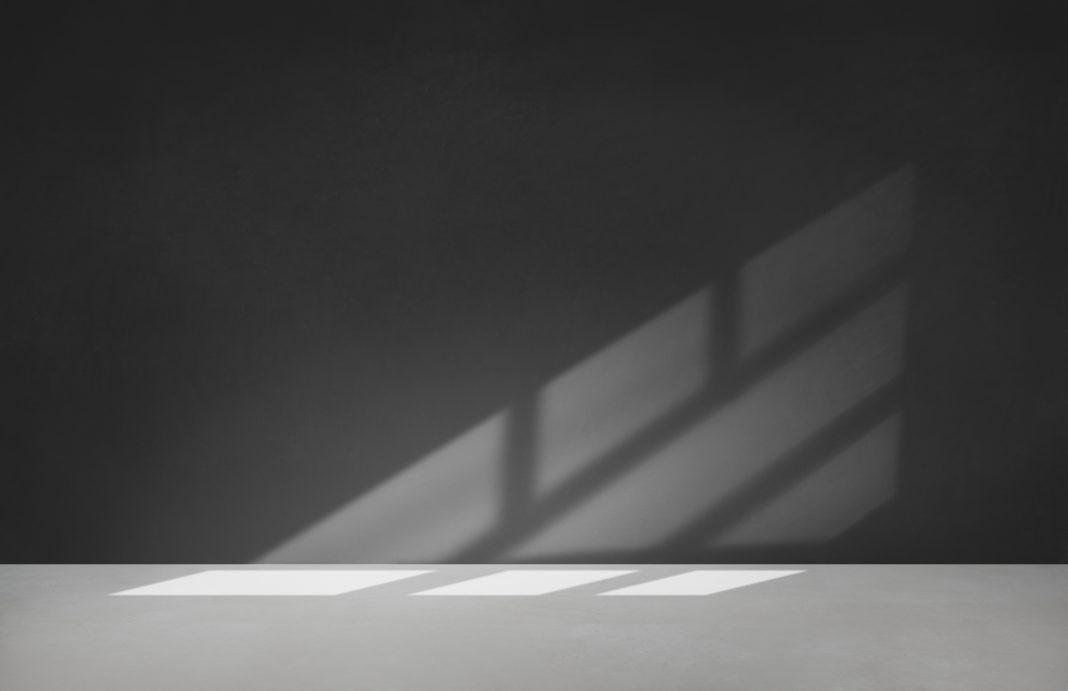 Black wall in an empty room with concrete floor