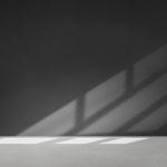 Black wall in an empty room with concrete floor