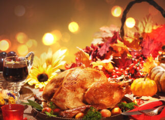 Roasted whole turkey on festive rustic table with autumn decoration for Thanksgiving Day